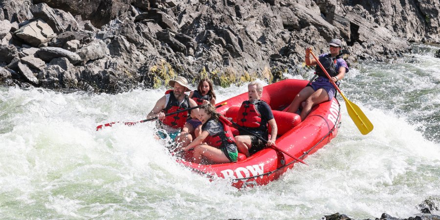 A red raft paddling through a rapid