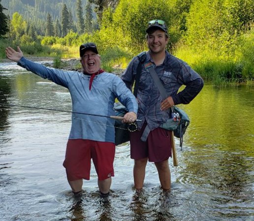 Two happy anglers wading in a scenic North Idaho river during an affordable Coeur d’Alene fly fishing tour