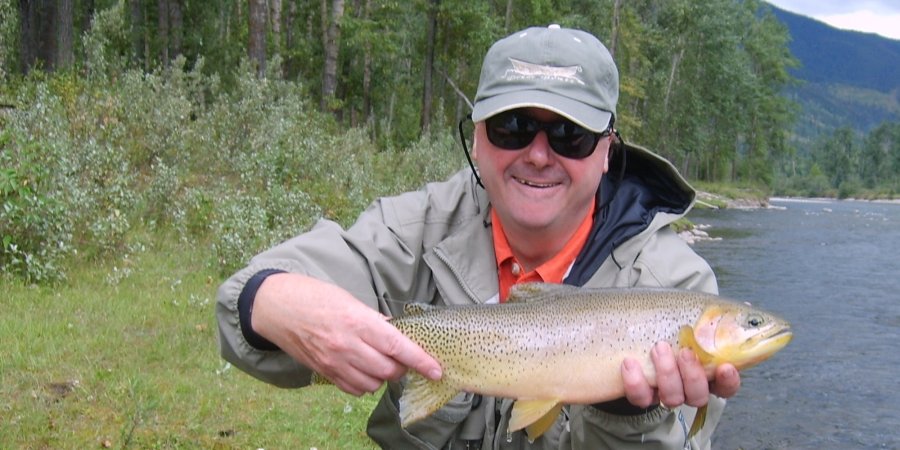 Angler holding a native trout during a guided walk-and-wade fly fishing tour near Coeur d’Alene, Idaho