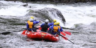 A red ROW adventures raft navigating through a rapid on the Lochsa river.
