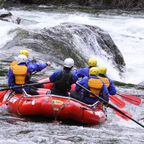 A red ROW adventures raft navigating through a rapid on the Lochsa river.